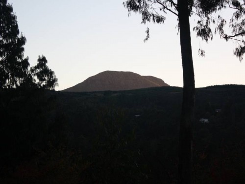 The rays of the rising sun catching the peak of Gaika's Kop.